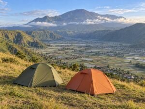 Camping tents overlooking Sembalun Valley with Mount Rinjani in the distance