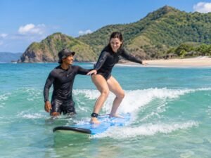 Local surf instructor helping a first time surfer in South Lombok